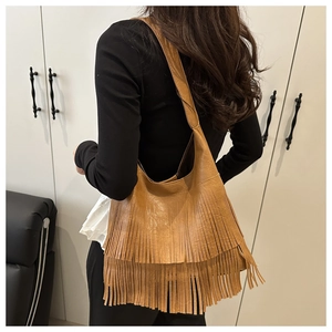 Close-up of brown fringe tote bag featuring retro leather material and large capacity