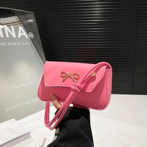 Chic pink shoulder bag with gold metal bow accent and knotted strap for summer fashion