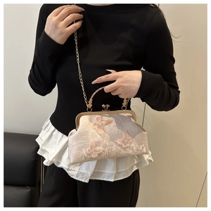 Vue détaillée du sac crème avec broderies papillons 3D et poignée en métal doré