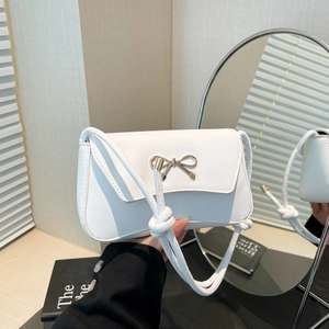 Chic white leather shoulder bag featuring a gold bow buckle and elegant knotted strap detail