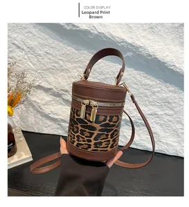 Detailed shot of coffee leopard print cylinder bag with dual zippers and leather handle