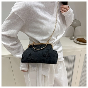 Détail du sac à bandoulière en dentelle noire avec papillon 3D et cadre en métal vintage