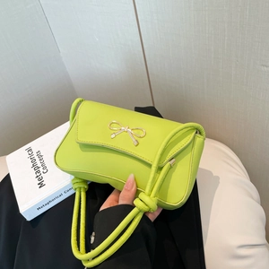 Neon green French baguette bag with golden bow and knotted shoulder strap detail
