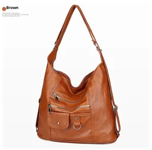Close-up of vintage brown soft leather crossbody bag with multiple zipper pockets