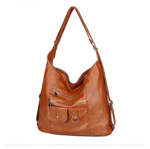 Detail of tan brown multi-pocket PU leather crossbody bag with silver zippers and soft finish