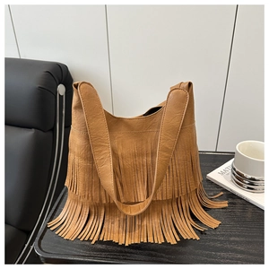 Détail d'un sac cabas en cuir marron avec franges bohèmes élégantes et doubles bandoulières