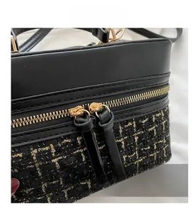 Detailed close-up of premium tweed texture and golden dual zipper on the black bucket bag