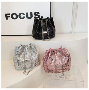 Three sequined bucket bags in black, silver, and pink with metallic chain straps