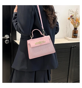 Detail of pink Kelly bag with sparkling glitter texture and elegant metal top handle
