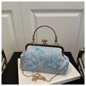 Détail du sac à main bleu clair brodé avec papillons 3D et poignée métallique dorée chic