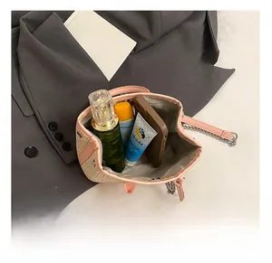Interior capacity detail showing pink straw handbag holding phone and perfume accessories