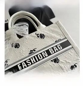 Detail of white PU leather tote with black rose pattern and lace ribbon on handle
