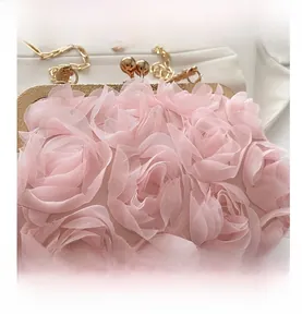 Details der rosa Rosenblütenstruktur und goldener Metallrahmen der Abendhandtasche