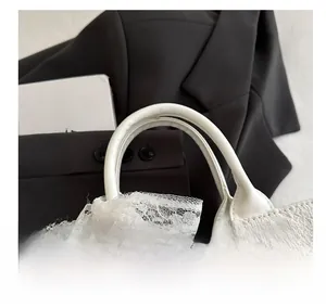 Detail of white tote bag with rose flower embroidery and lace ribbon bow on the handle