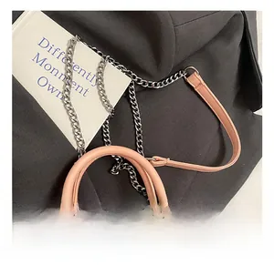 Detail of pink leather handles and woven texture on a contrast shoulder bag