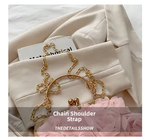 Detail einer rosa 3D-Blumenhandtasche mit goldener Kette auf einem beigen Blazer