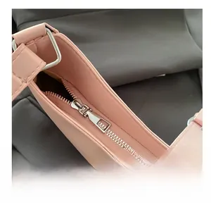 Nahaufnahme des glatten Silberreißverschlusses und der Schnalle einer rosa Lederhandtasche