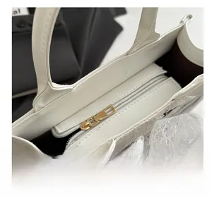 Detail of smooth gold zipper and white leather stitching on large capacity tote bag