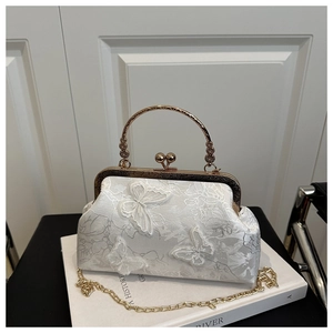 Détail de la broderie en dentelle blanche avec papillons 3D et poignée dorée chic