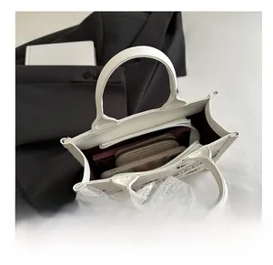 Internal view of large white leather tote bag with lace detail showing spacious capacity