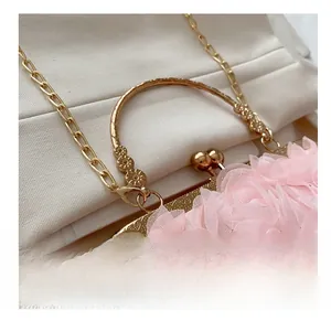 Detailansicht der Abendtasche mit rosa Netzblumen und graviertem goldenem Verschluss