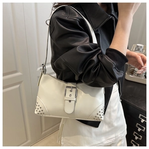 Detail of white leather baguette bag with silver buckle strap and rivet accents
