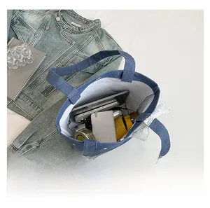 Detail view of denim tote bag showing interior capacity with embroidery and lace
