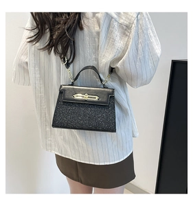 Detail of crossbody handbag with black leather stitching and shiny sequin lower panel