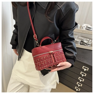 Detail of red tweed and leather patchwork handbag featuring gold hardware and zipper