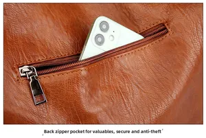 Detailed view of rear anti-theft zipper pocket on brown pebbled leather crossbody bag