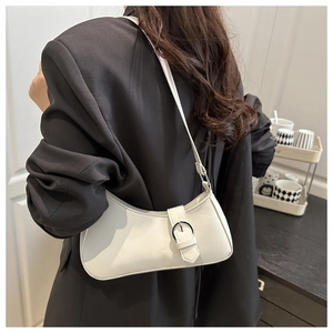 Detail der weißen Mondsichel-Tasche mit Silberschnalle, getragen von einem Modell