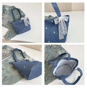 Detail view of denim tote bag with floral embroidery and white lace bow accessory