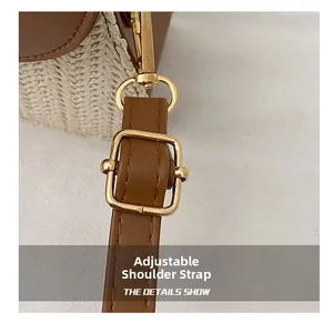 Detail of adjustable leather strap and gold buckle on a woven straw tote bag