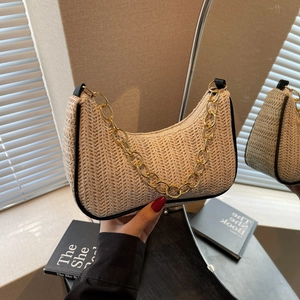 Chic cream straw crescent bag with black piping and gold chunky chain strap
