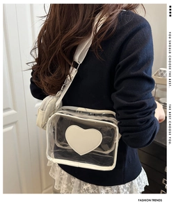Dettaglio di una modella con la borsa a tracolla in PVC trasparente bianca e cuore decor