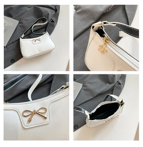 Détails du sac sous le bras blanc avec ferrure papillon dorée et tirette fleurie
