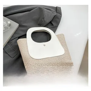 Detailed view of handmade woven tote bag with smooth white leather trim and round top handle