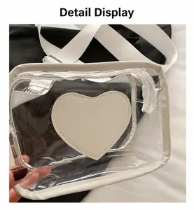 Close-up of transparent PVC crossbody bag with white heart patch and zipper details