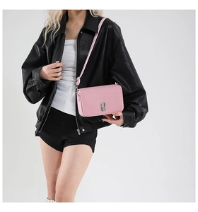 Detail of pink glitter crossbody bag featuring a silver metal double J-shaped buckle
