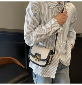 Close-up of saddle bag details featuring cream canvas and leather trim on a model