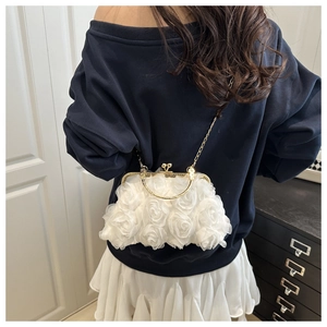 Detail der weißen 3D-Organza-Rosen auf der eleganten Abendtasche mit goldenem Verschluss