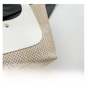Detail shot of woven straw texture with white leather stitching and metal buckle