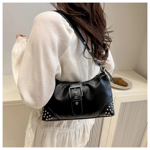 Close-up of black retro underarm bag featuring silver rivets and metal buckle detail
