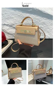 Detail view of gold trapezoid handbag with shimmering sequins and gold clasp closure