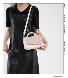 Elegante borsa a tracolla beige da donna con una patta testurizzata mostrata su modella