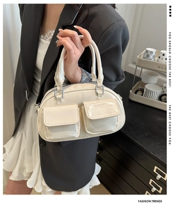 Detail of cream bowling tote bag featuring double buckled pockets and silver hardware