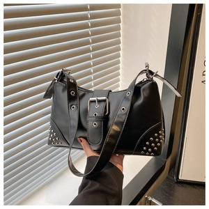 Detail view of the silver metal rivets and buckle on this black leather tote bag