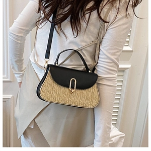 Fashionable straw shoulder bag with black leather accents and golden oval metal lock