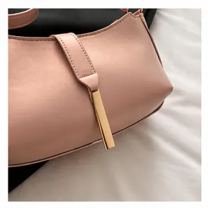 Close-up detail of a pink underarm shoulder bag with elegant metal hardware