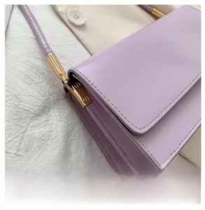 Detail of lavender purple shoulder bag showing golden hardware and stitching quality